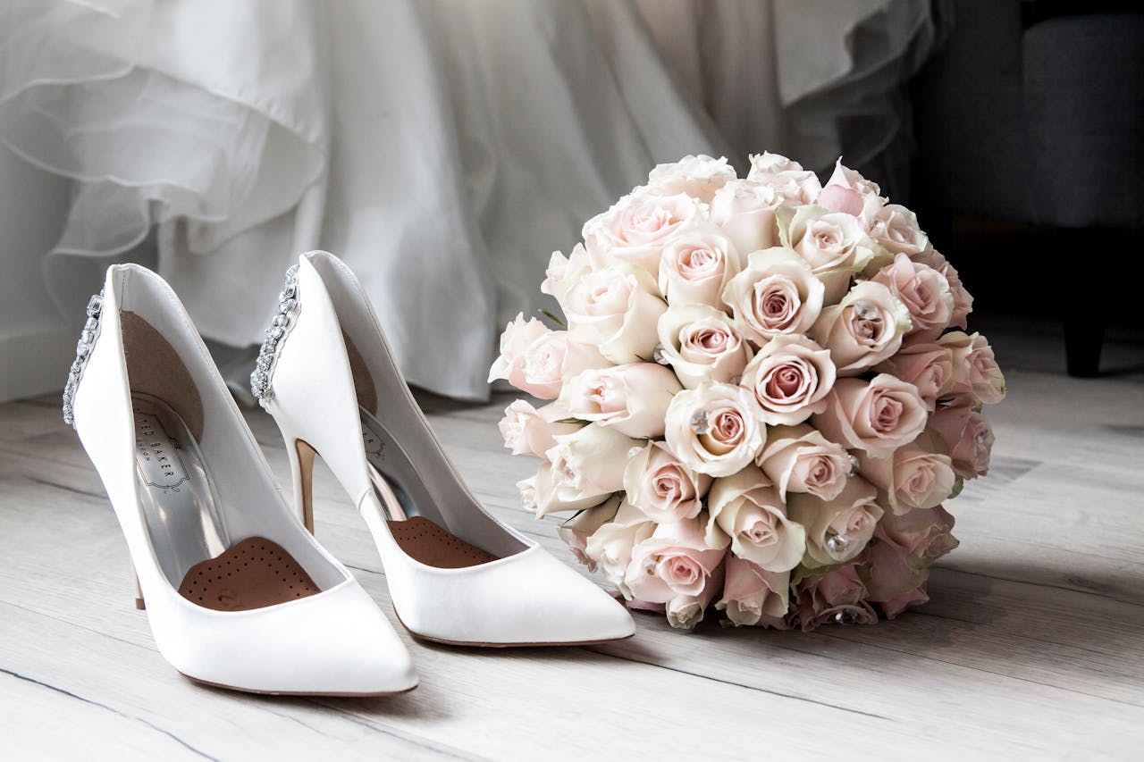 Elegant bridal shoes and bouquet of roses perfect for wedding inspirations.